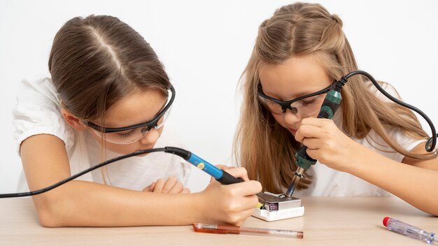 Chicas con gafas protectoras haciendo experimentos científicos.