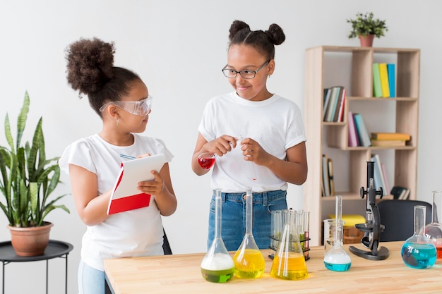 Chicas con gafas de seguridad divirtiéndose con experimentos de química