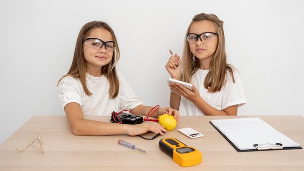 Chicas con gafas de seguridad haciendo experimentos científicos.