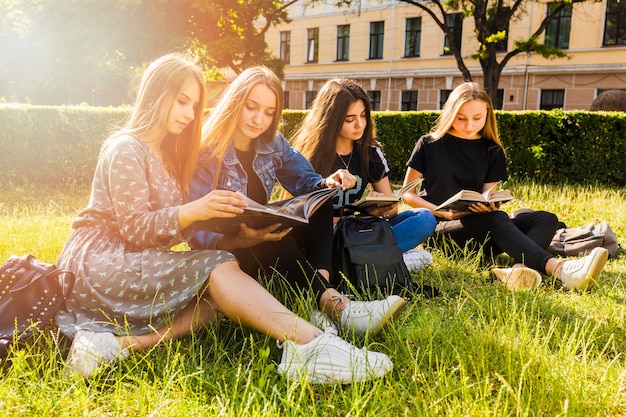 Chicas guapas adolescentes leyendo en el parque