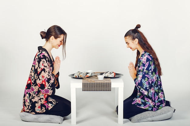 Chicas guapas comiendo un sushi en un estudio