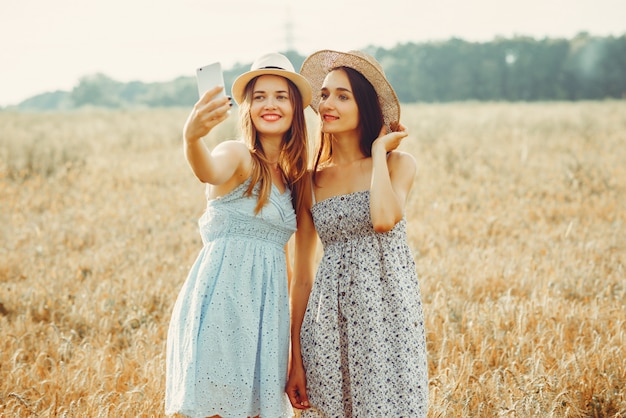 Las chicas guapas descansan en un campo.