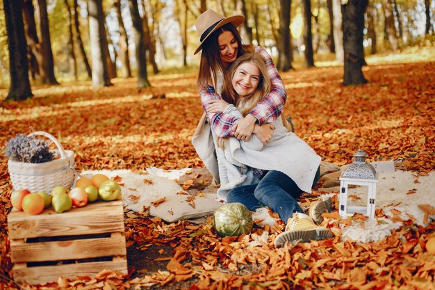 Chicas guapas se divierten en un parque de otoño