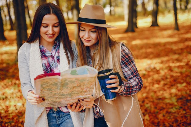 Chicas guapas se divierten en un parque de otoño