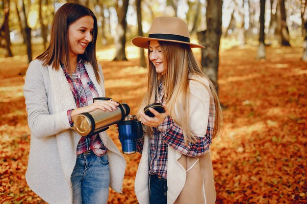 Chicas guapas se divierten en un parque de otoño