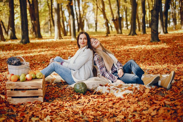 Chicas guapas se divierten en un parque de otoño