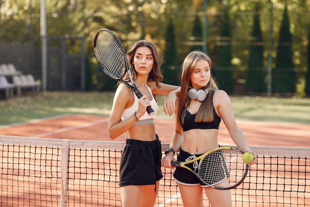 Chicas guapas y elegantes en la cancha de tenis