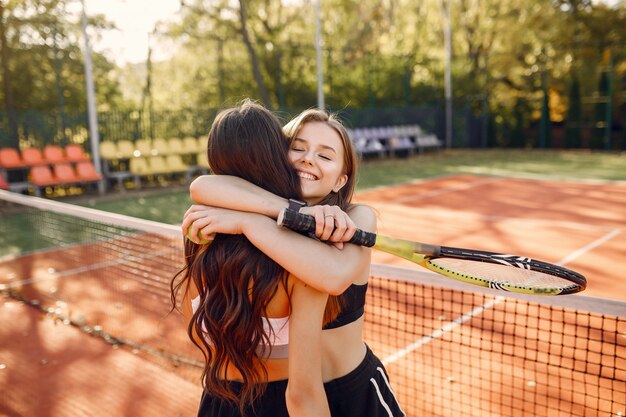 Chicas guapas y elegantes en la cancha de tenis