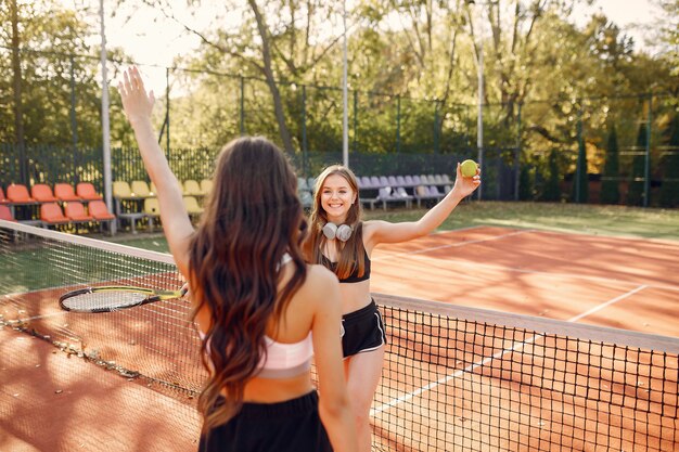 Chicas guapas y elegantes en la cancha de tenis