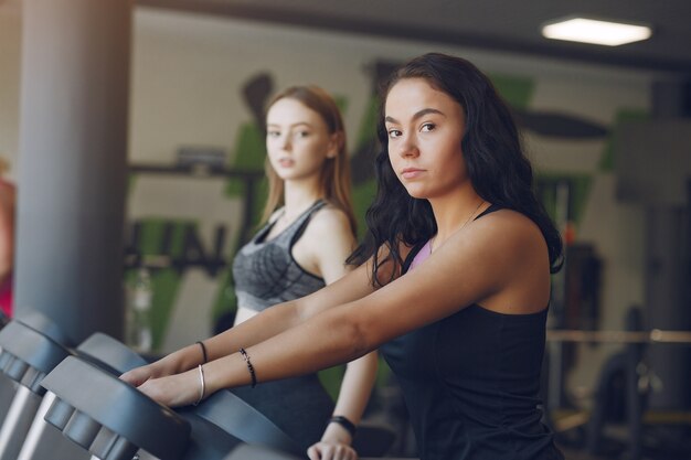 Chicas guapas en un gimnasio. Señoras deportivas en ropa deportiva. Entrenamiento de amigos