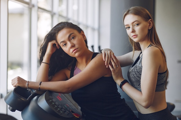 Chicas guapas en un gimnasio. Señoras deportivas en ropa deportiva. Entrenamiento de amigos