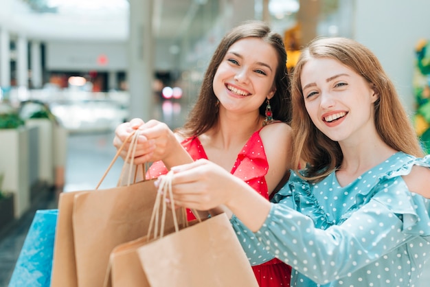 Chicas guapas posando con bolsas de la compra.