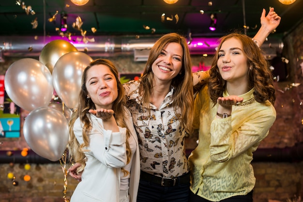 Foto gratuita chicas guapas sonrientes posando y sonriendo en una discoteca