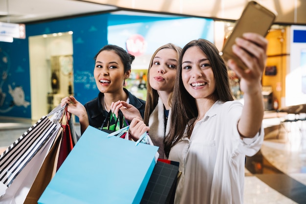 Chicas guapas tomando selfie en el centro comercial