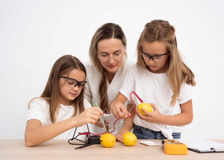 Foto gratuito chicas haciendo experimentos científicos con maestra y limones.