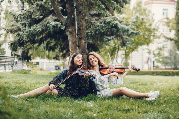 Chicas hermosas y románticas en un parque con un violín