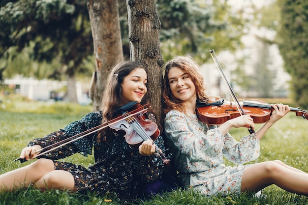 Chicas hermosas y románticas en un parque con un violín