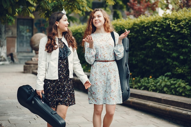 Chicas hermosas y románticas en un parque con un violín