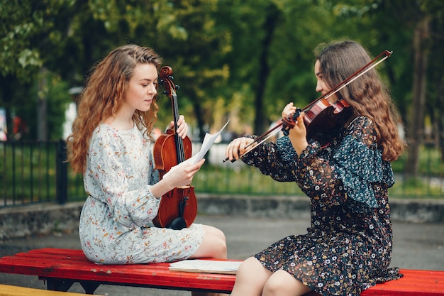 Chicas hermosas y románticas en un parque con un violín