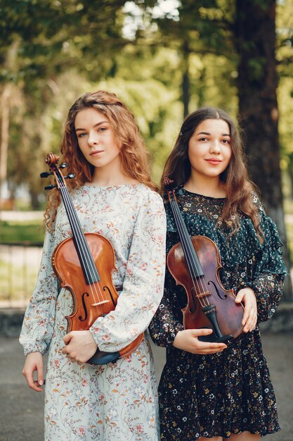 Chicas hermosas y románticas en un parque con un violín