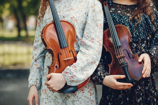 Chicas hermosas y románticas en un parque con un violín