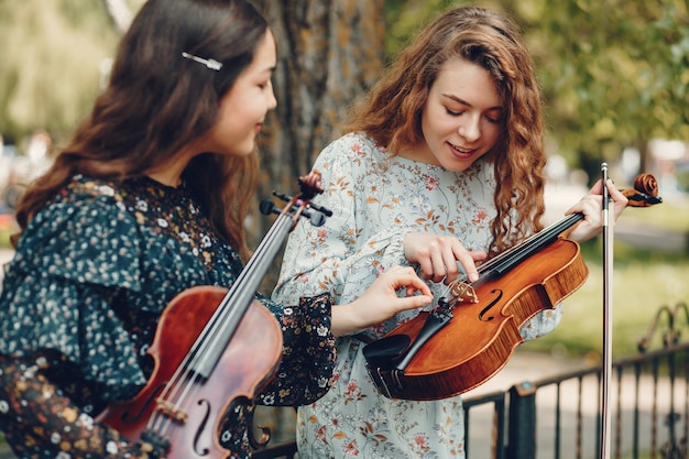 Chicas hermosas y románticas en un parque con un violín