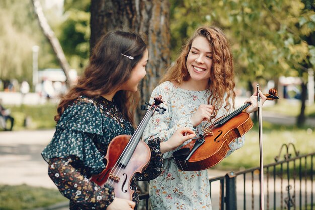 Chicas hermosas y románticas en un parque con un violín