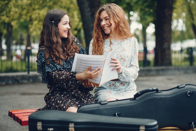 Chicas hermosas y románticas en un parque con un violín