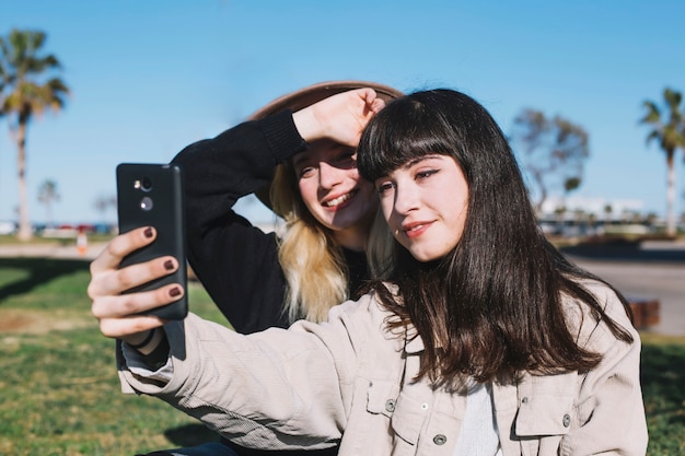 Chicas jóvenes brillantes tomando selfie para memoria