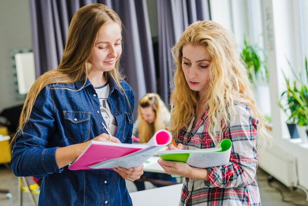 Chicas jóvenes compartiendo con notas