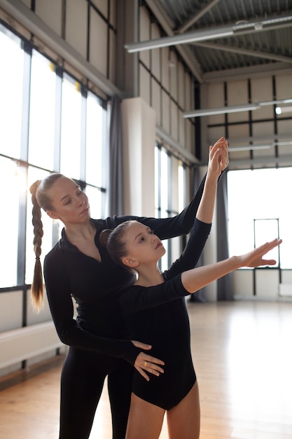 Chicas jóvenes entrenando juntas en gimnasia