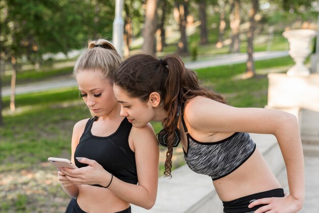 Chicas jóvenes felices después de entrenar en el parque