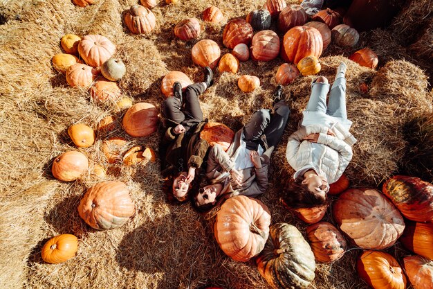 Las chicas jóvenes mienten en los pajares entre calabazas