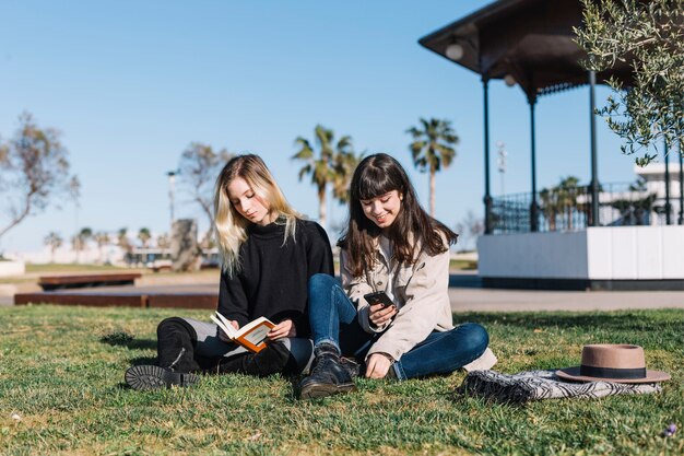 Chicas jóvenes, refrigeración, en, césped, en el estacionamiento