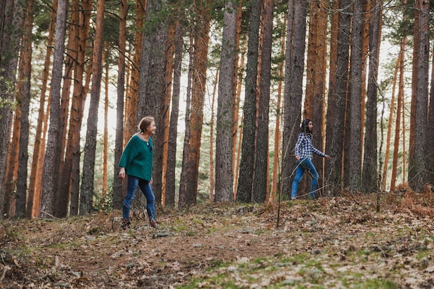 Chicas jugando con los árboles en el bosque