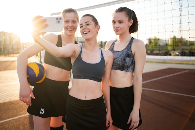 Chicas jugando voleibol y tomando selfie