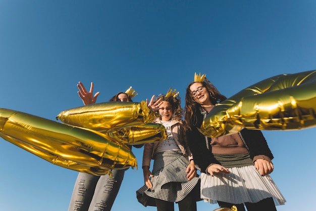 Chicas lanzando globos en forma de letras