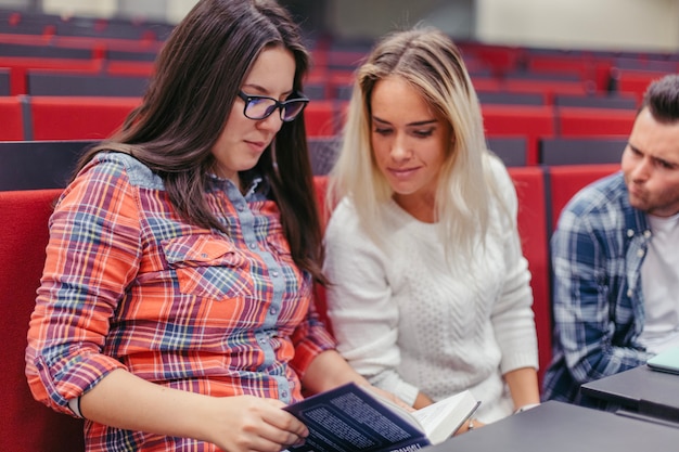 Chicas leyendo un libro en la universidad