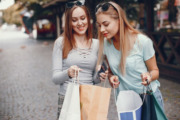 Chicas lindas con bolsa de compras en una ciudad.