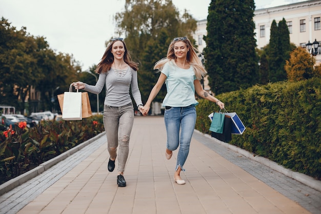 Chicas lindas con bolsa de compras en una ciudad.