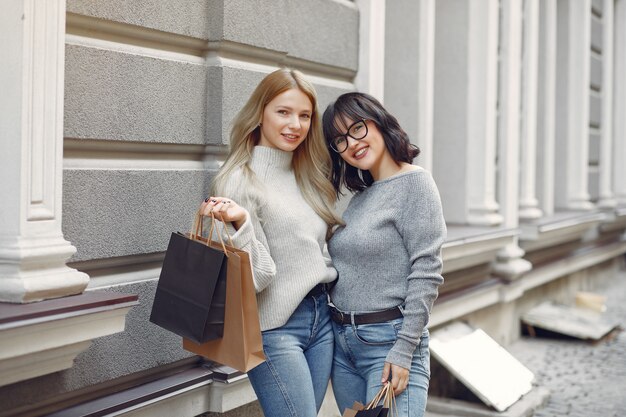 Chicas lindas con bolsa de compras en una ciudad