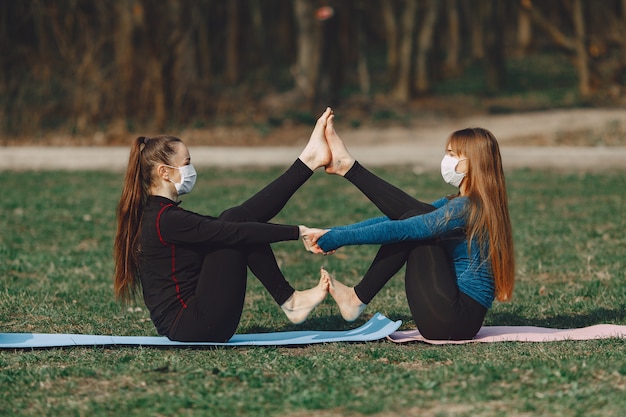 Chicas lindas haciendo yoga en máscaras