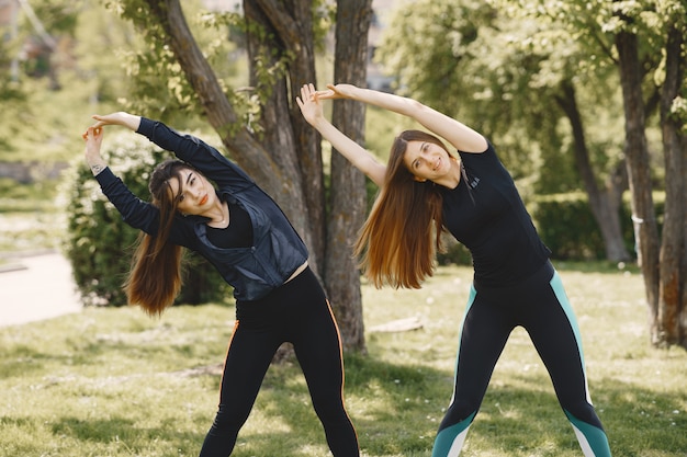 Chicas lindas haciendo yoga en un parque de verano