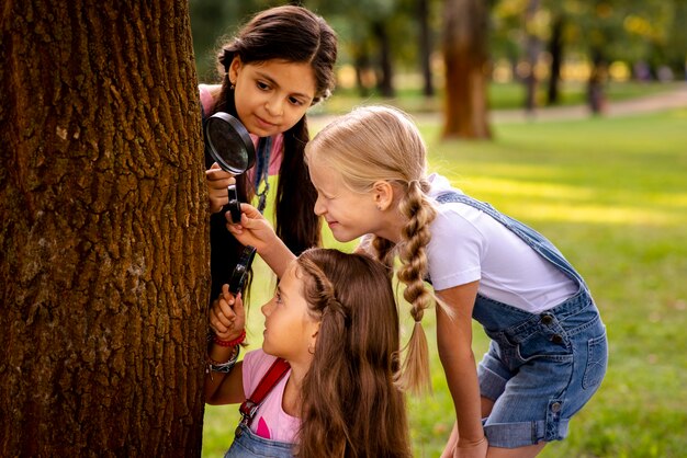 Chicas mirando el árbol acechan a través de la lupa