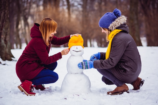 Chicas moldeando un muñeco de nieve