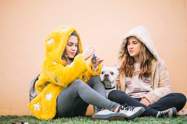 Foto gratuita chicas con perro en césped