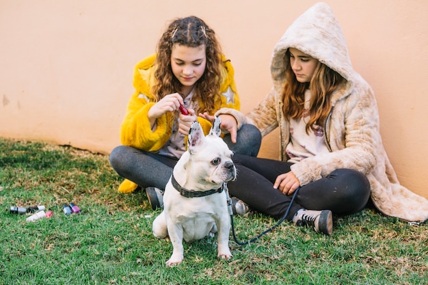 Foto gratuita chicas con perro en césped