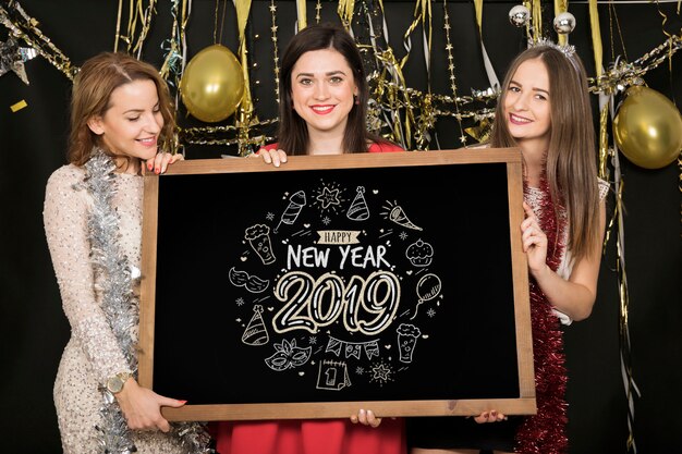 Foto gratuita chicas con pizarra negra en fiesta de año nuevo 2019