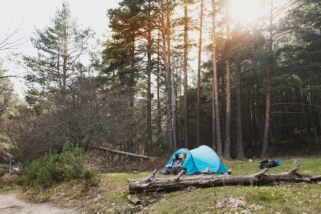 Chicas relajadas acampando en el bosque