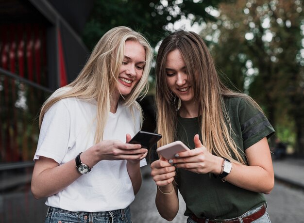 Chicas revisando sus mensajes en los teléfonos